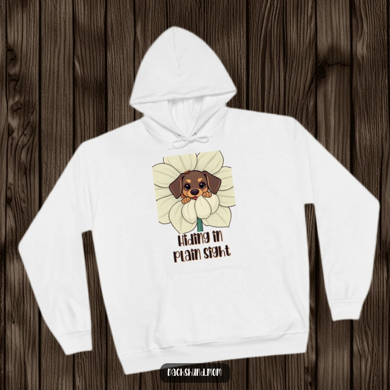 Funny kawaii dachshund hoodie, a curious little dog peeking from behind a large flower, blending warmth with humor.